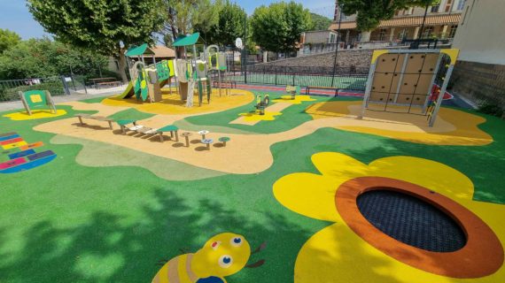 Aire de jeux colorée pour enfants avec toboggan, trampoline intégré et décorations en forme de fleurs et d’abeilles.