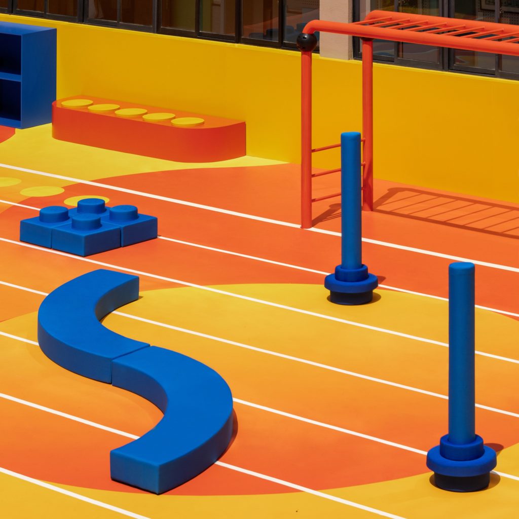 Détail aire de jeux modulaire LEGO Nike avec modules bleus et agrès oranges