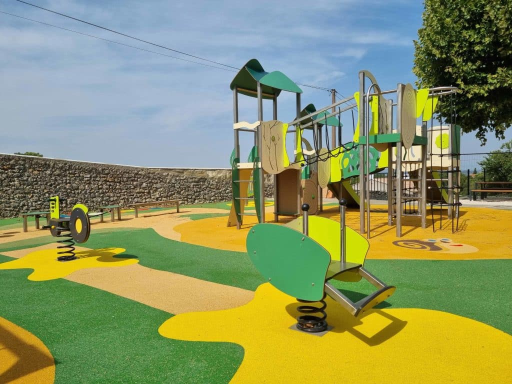 Aménagement multifonctionnel avec structure multi-activités, jeu à ressort tracteur et sol souple coloré jaune et vert