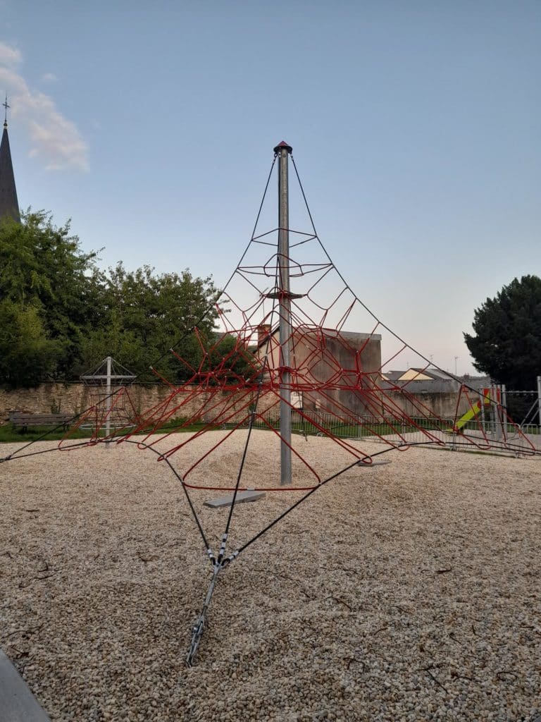 Structure de grimpe style toile d'araignée pour enfants installée sur une aire de jeux publique sécurisée