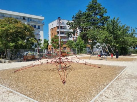 Structure pyramide des codes installée sur une aire de jeux extérieure avec sol en copeaux de bois