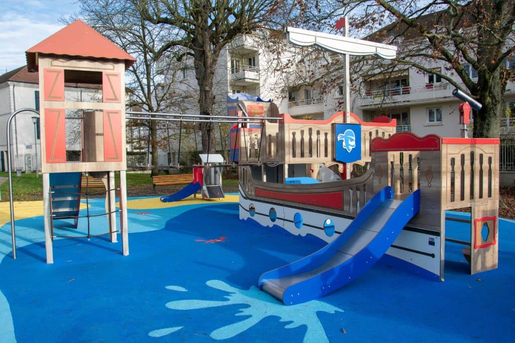 Structure de jeux en forme de bateau pirate avec toboggan et tour d'escalade sur sol amortissant en EPDM bleu