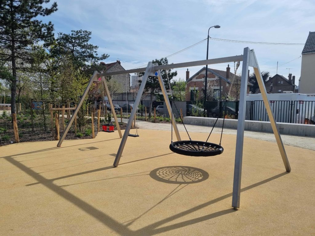 Structure de balançoire moderne en métal avec un siège nid d'oiseau, une nacelle et un siège classique sur un sol amortissant beige.