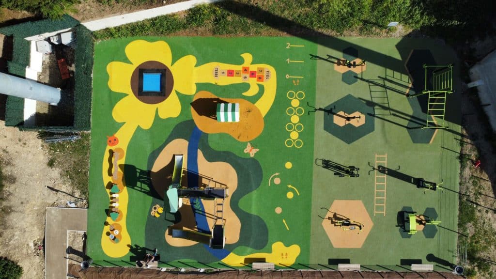 Vue aérienne de l'aire intergénérationnelle avec un espace jeux enfants et un espace fitness sur sol souple en EPDM aux Pennes Mirabeau dans les Bouches-du-Rhône.
