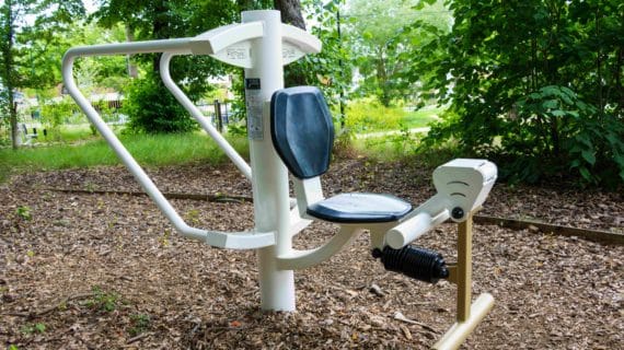 Appareil fitness duo barres parallèles quadriseat blanc doré sur sol en copeaux bois à Clamart