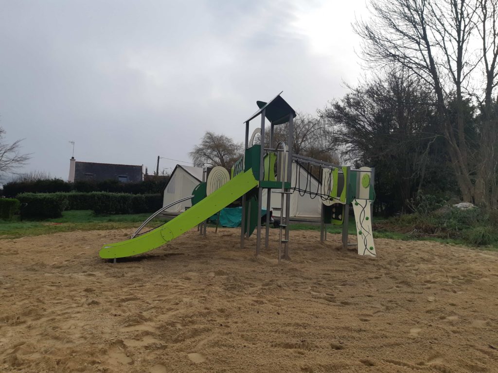 Aire de jeux pour camping, structure Organik sur un sol souple en sable.