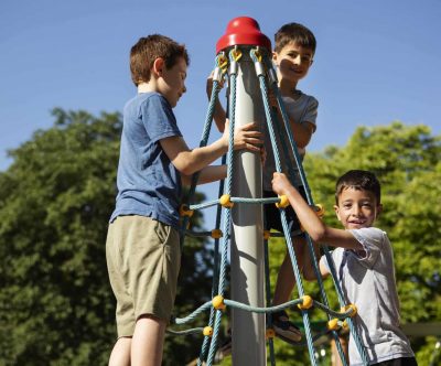 Photo d'enfants jouant au sommet d'une structure de pyramide des cordes
